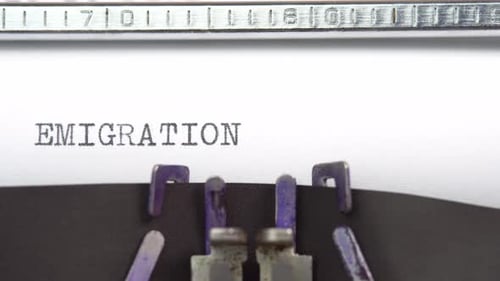 Emigration word closeup being typing and centered on a sheet of paper on old vintage typewriter