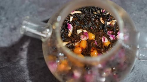 Topdown View Of Floral Looseleaf Tea In Glass Teapot Colorful Rose Petals And Berries Visible