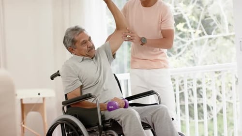 Senior Man Lifts Weights With Young Adult Assistant