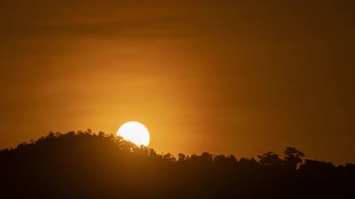 Timelapse of dramatic sunrise with orange sky in a sunny day.