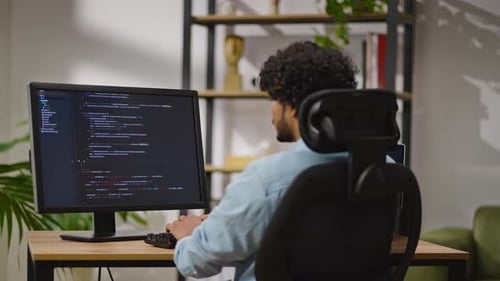 Indus Man Types Source Code on PC Sitting in Home Office