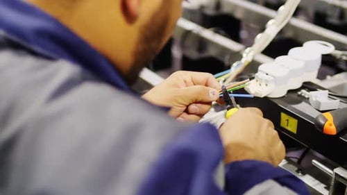 Electrician Works with Wires in Insulation at Construction