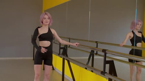 Graceful Attractive Female Ballet Dancer Rehearsing at Barre in Dance Studio