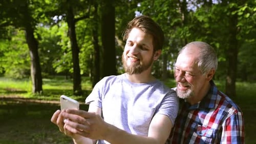 Hipster Son and His Senior Father in Park Taking Selfie