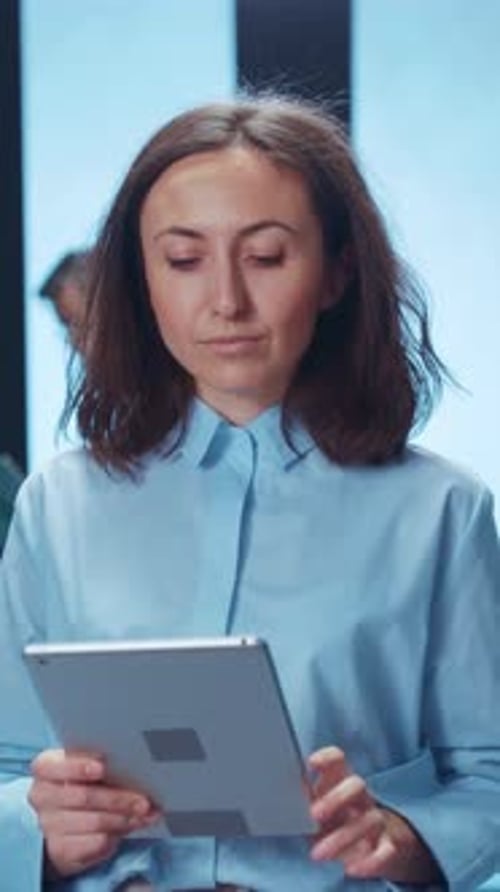 Woman Holds Tablet in Workplace Environment