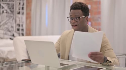 Young Adult Man Celebrates Success at Home Office