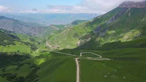Aerial View of a Beautiful Green Valley and Road in the Mountains