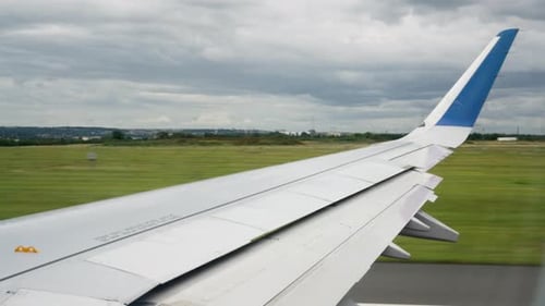 Airplane wing moves fast on an airport runway during takeoff acceleration