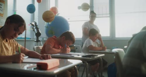 Elementary School Students Writing Exam or Doing Tasks in Notebooks