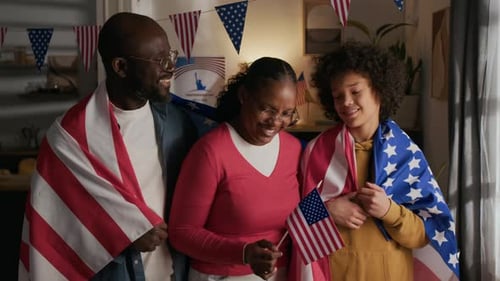 Portrait of Smiling Black Family Wrapped in American Flags on Independence Day