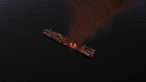 Aerial View of Cargo Container Ship on Fire at Sea with Thick Smoke and Burning Deck