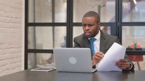 Worried Man Working at Laptop in Office
