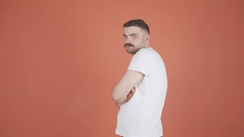Man with Mustache Poses in Front of Orange Background