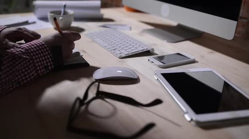 Person Working at Desk with Computer and Tablet