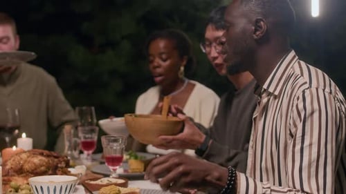 Friends Enjoying Dinner Together Outdoors at Night