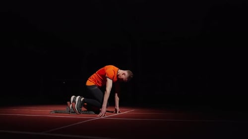 Sport- und Energiesprintertraining allein im Stadion Läufer bereitet sich auf den Start vor und läuft schnell