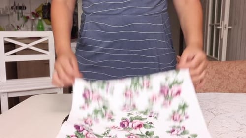 Woman Folding Decorative Floral Towels