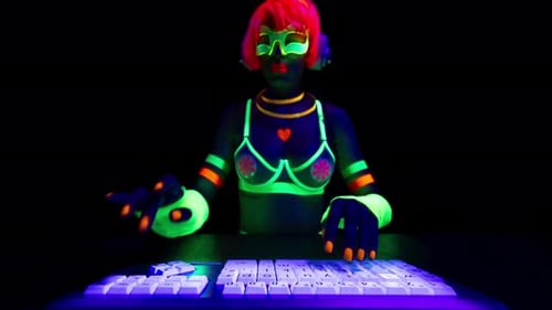 Woman Typing on Neon Keyboard in the Dark