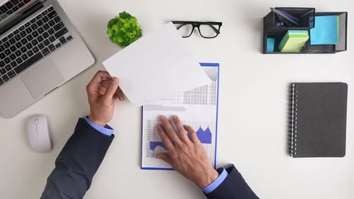 Signing Contract with Financial Paperwork on Desk