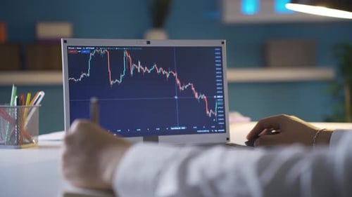 Person Analyzing Stock Market Graph on Laptop