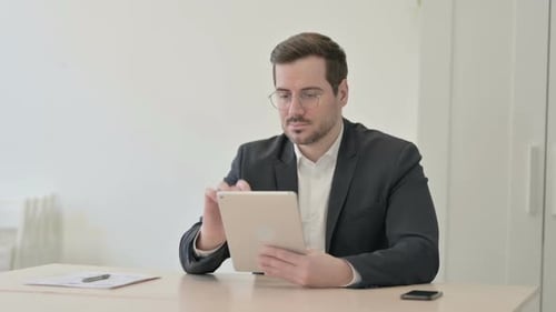 Man Using Tablet in Bright Office Setting