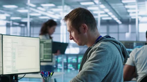 Portrait of Smiling Engineer Inspecting Server Rows in Data Center