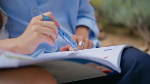 Cahier pointant la main pour enfant étudiant à l'extérieur en gros plan, enfant fille faisant ses devoirs