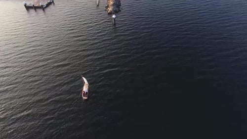 Alone sail boat in the ocean, sail boat by the shore. Blue water sail boat.