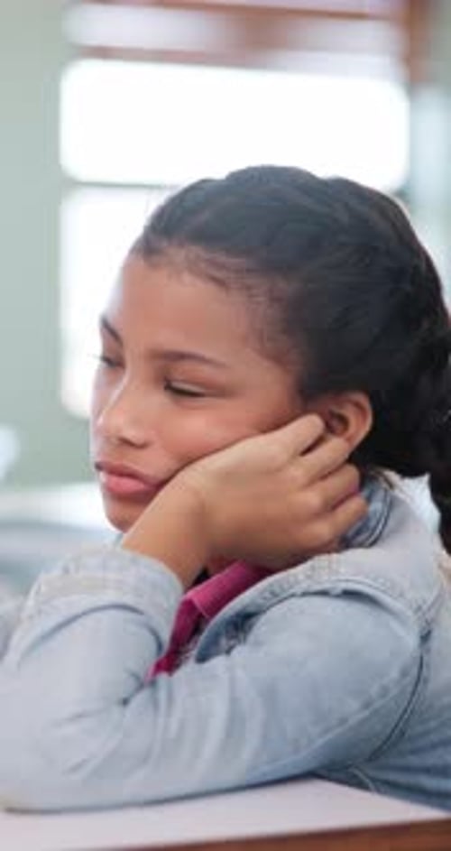 Bored, education and girl child at desk in classroom for development, future or growth