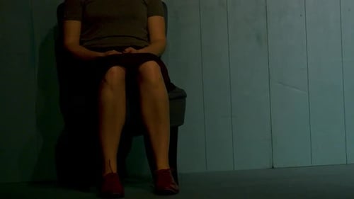 Sitting Still Indoors on a Chair in Front of Wall