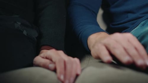 Man and Woman Holding Hands in Intimate Gesture