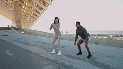 Athletic Man and Woman Working Out by the Sea