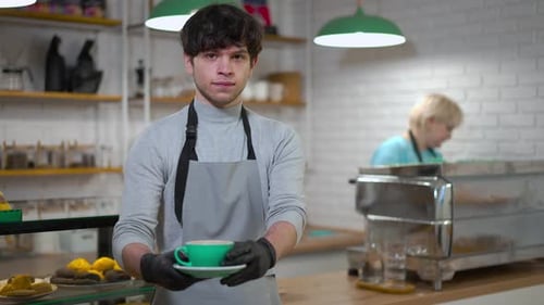 Barista Serving Coffee in Cafe Setting