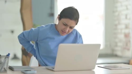 Young Woman Experiencing Back Pain at Desk