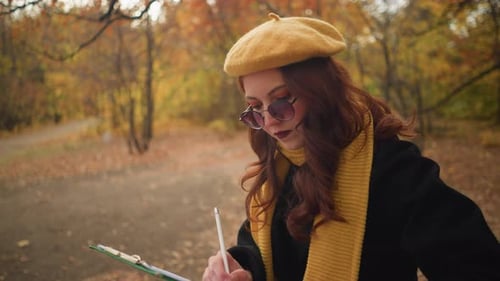 RedHaired Lady Writing in Quiet Autumn Park