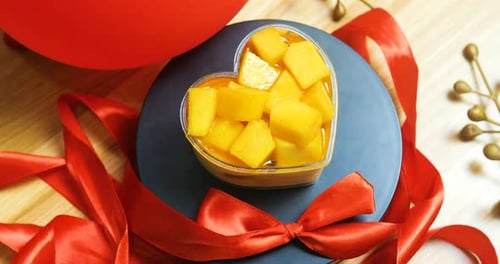 Heart Shaped Mango Bowl Surrounded by Red Ribbon