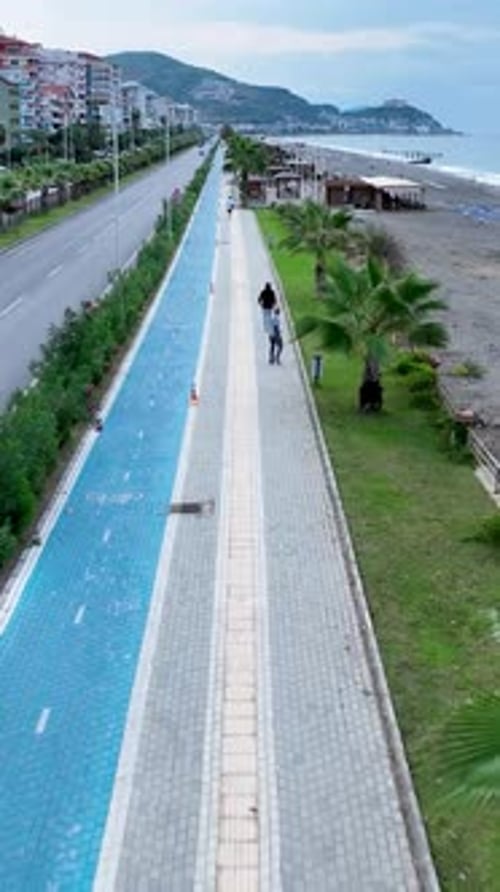 Vertical Video People Walk Along the Promenade Rest on the Mediterranean Sea