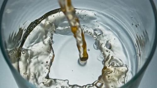 Beverage Pouring Into Glass With Bubbles Inside