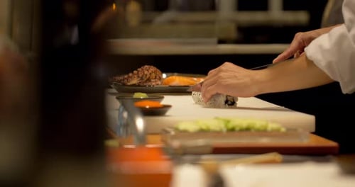 Chef Cuts Sushi Rolls in Restaurant Kitchen