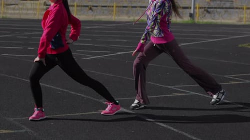 Las niñas hacen ejercicios de entrenamiento antes de la carrera: ejercicio integral