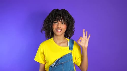 Smiling Woman Gives Okay Sign in Studio