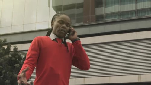 Steadicam Shot Of Good Looking African American Man Doing Business On His Cell Phone In Modern City.