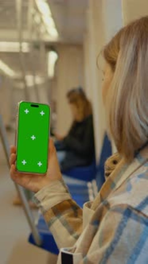 Vertical Screen Mother Showing Mockup Green Screen Smartphone on Subway Train