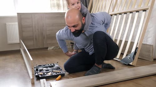 Father and Child Assembling Bed Together at Home