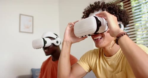 Two Young Adults Experiencing Virtual Reality Headsets Indoors