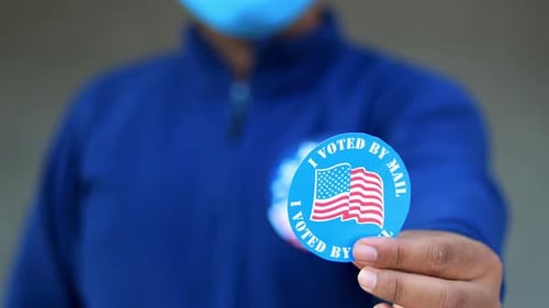 Putting on I Voted by Mail Sticker