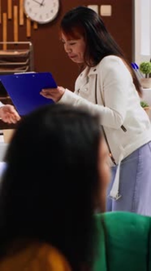 Vertical Video Hotel Guest Signing Registration Papers at Front Desk