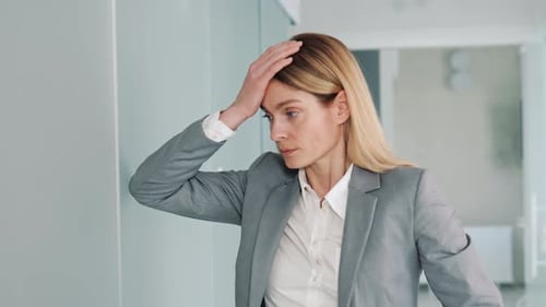 Sad Young Disappointed Business Woman Holds Hand to Head Problems at Work