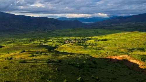 A large, grassy field with a cloudy sky in the background