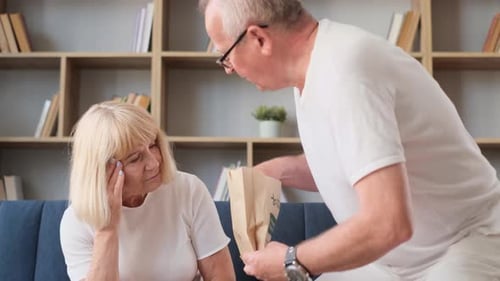 Husband Helping Wife Get Medication From Bag